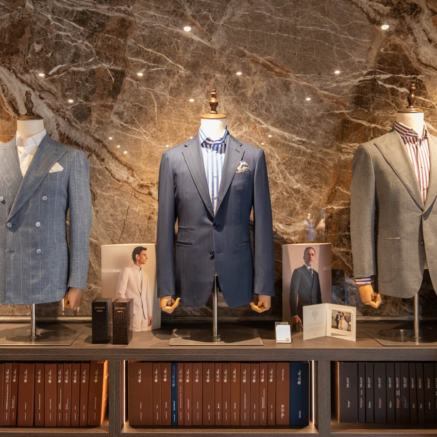 LECIANO Showroom – drei Sakkos vor der Marmorwand über den Stoffbüchern
